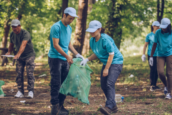 Man and woman picking up trash as a volunteer in an article about how to handle toxic volunteers