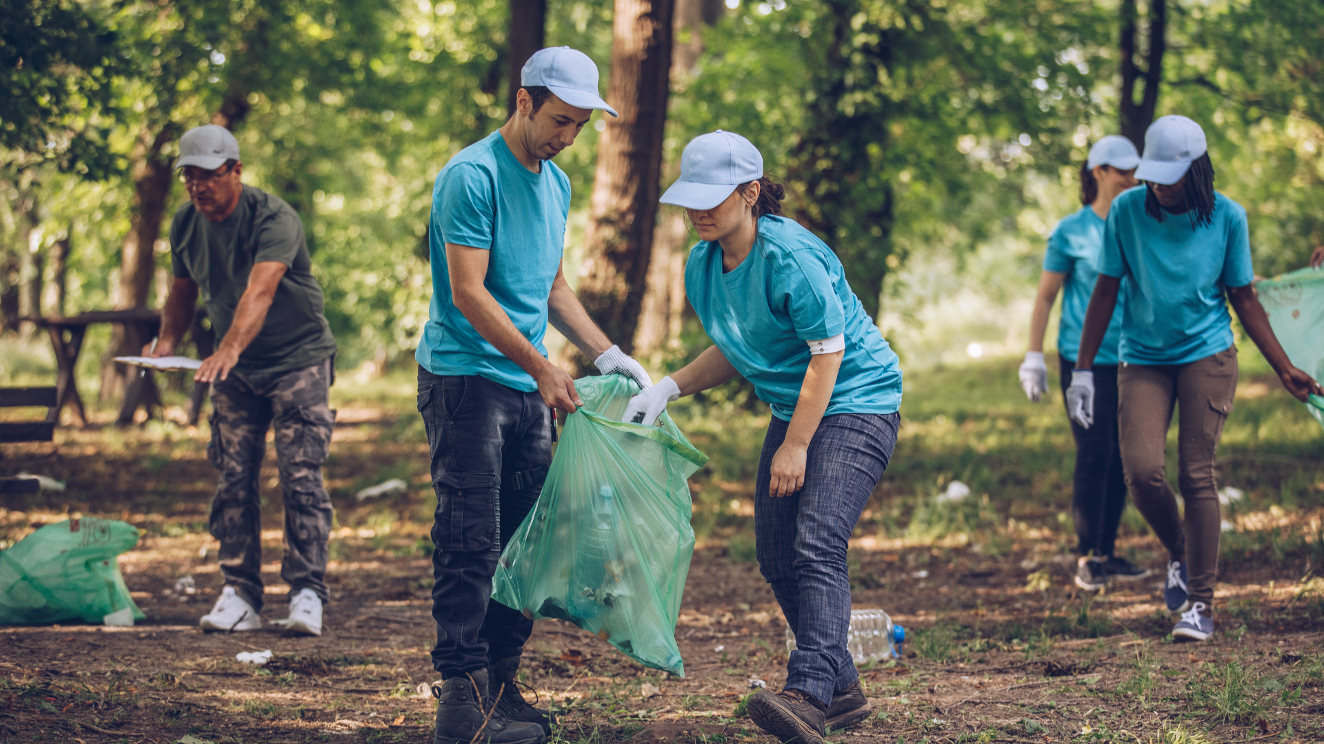 Man and woman picking up trash as a volunteer in an article about how to handle toxic volunteers