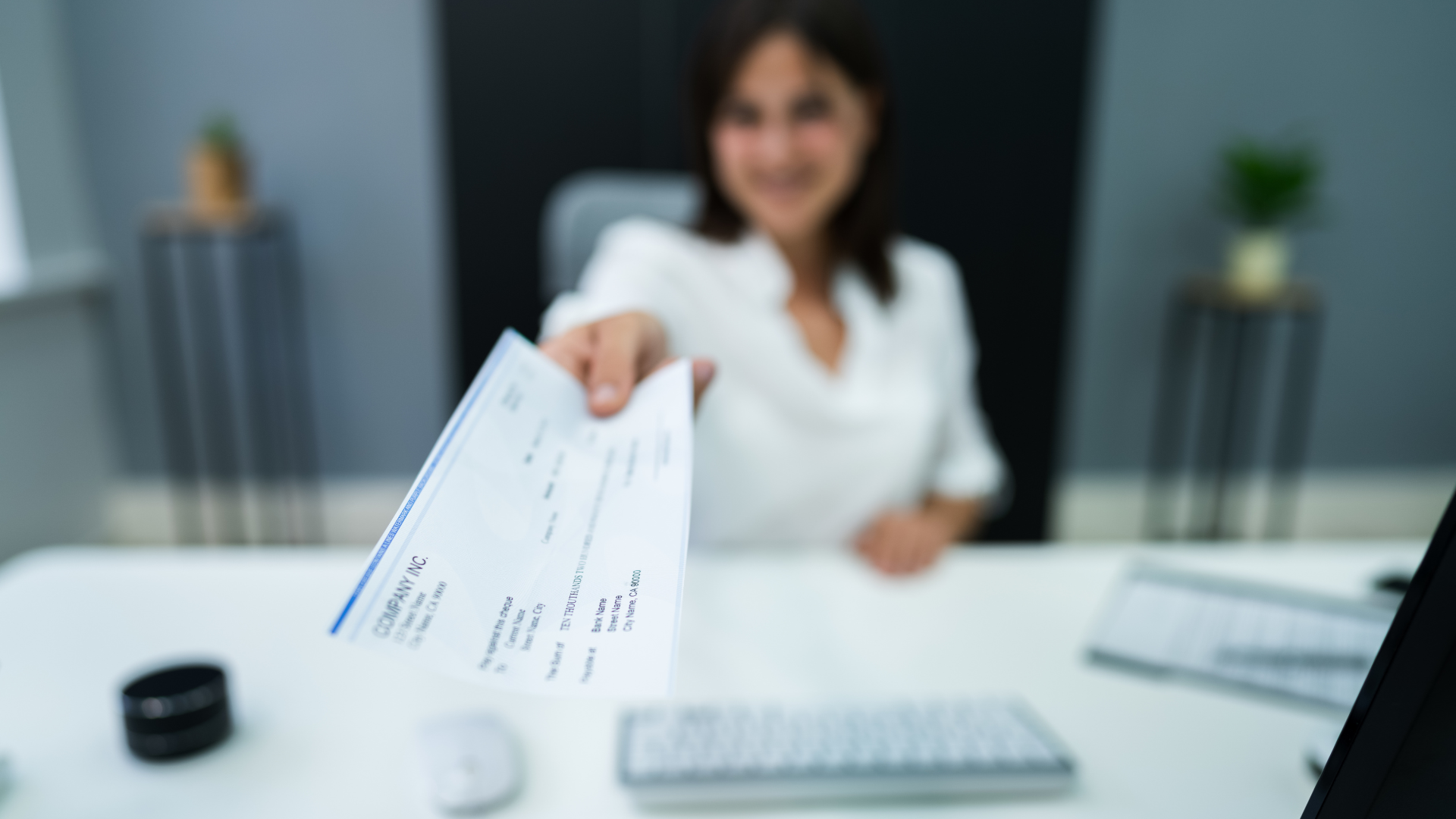 Woman handing a person their paycheck in an article about Garnished wages.