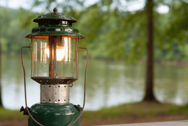 camping lantern in a forest in a press release about YMCA Camp